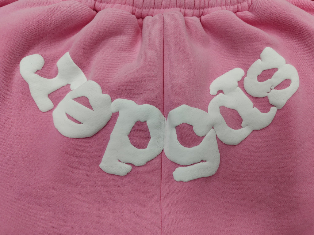 pink Sp5der jogger shorts feature a prominent white "sp5der" bubble letter graphic across the front