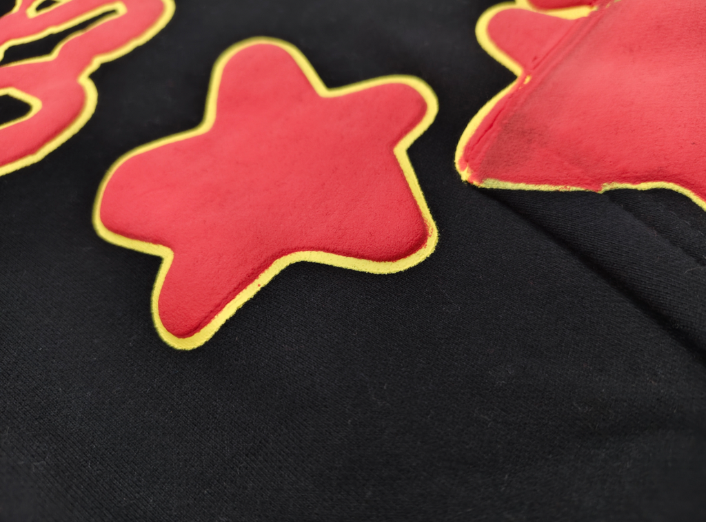 Sp5der x UY SCUTI Hoodie in black features prominent red star graphics
