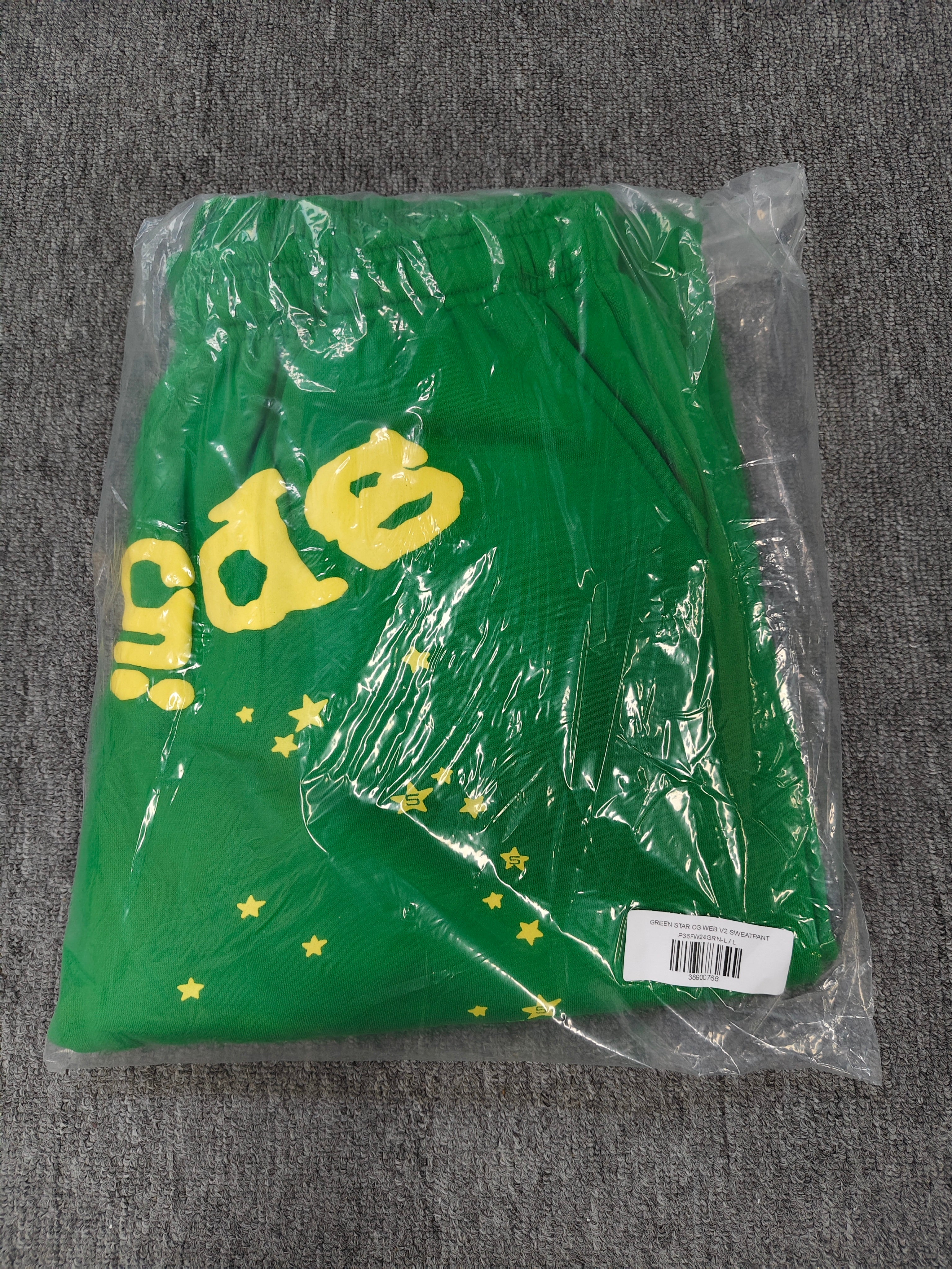 Sp5der Star OG Web V2 Sweatpants in the Slime Green colorway, featuring scattered yellow star motifs and a yellow brand graphic