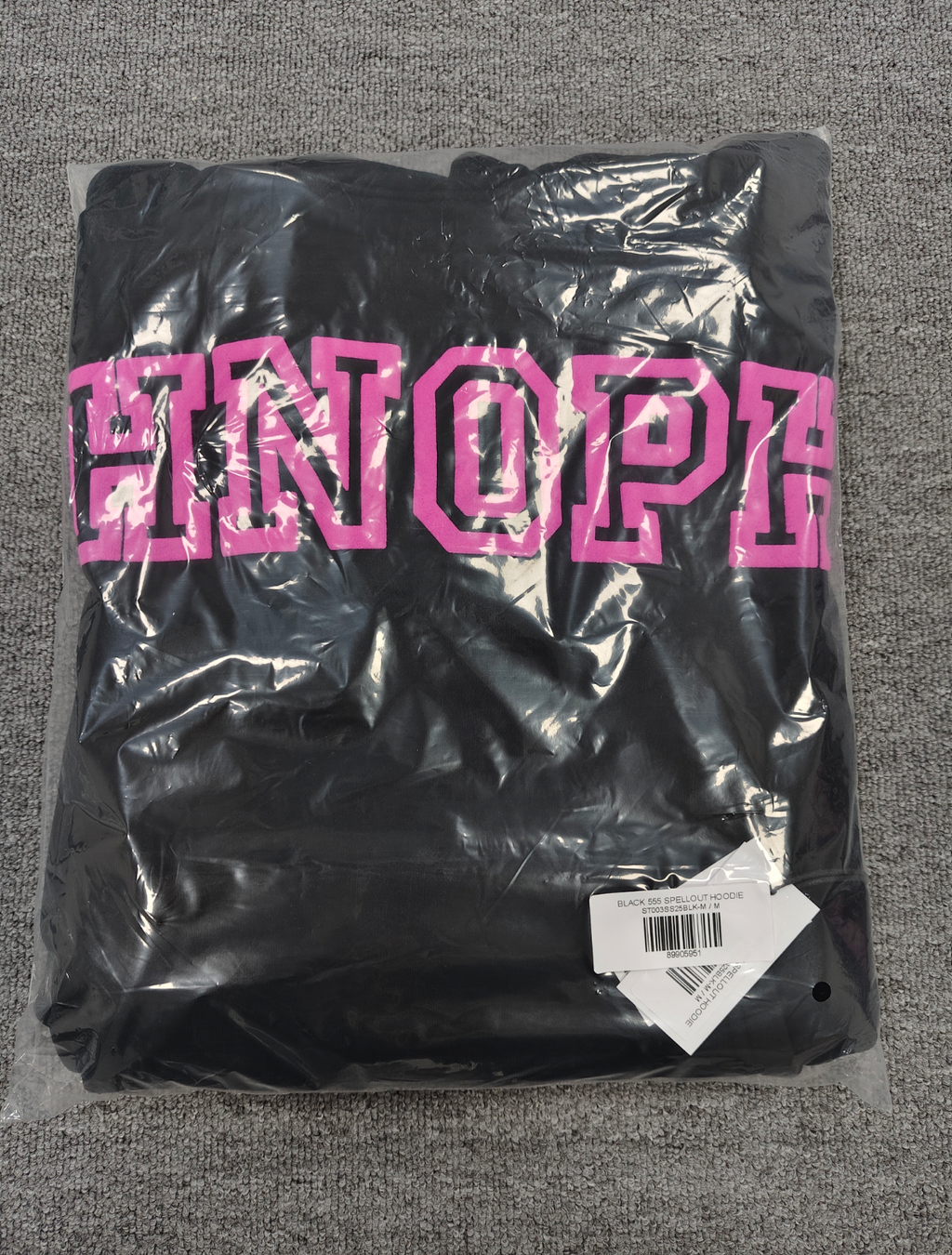 a black Sp5der Arachnophobia hoodie with vibrant pink lettering