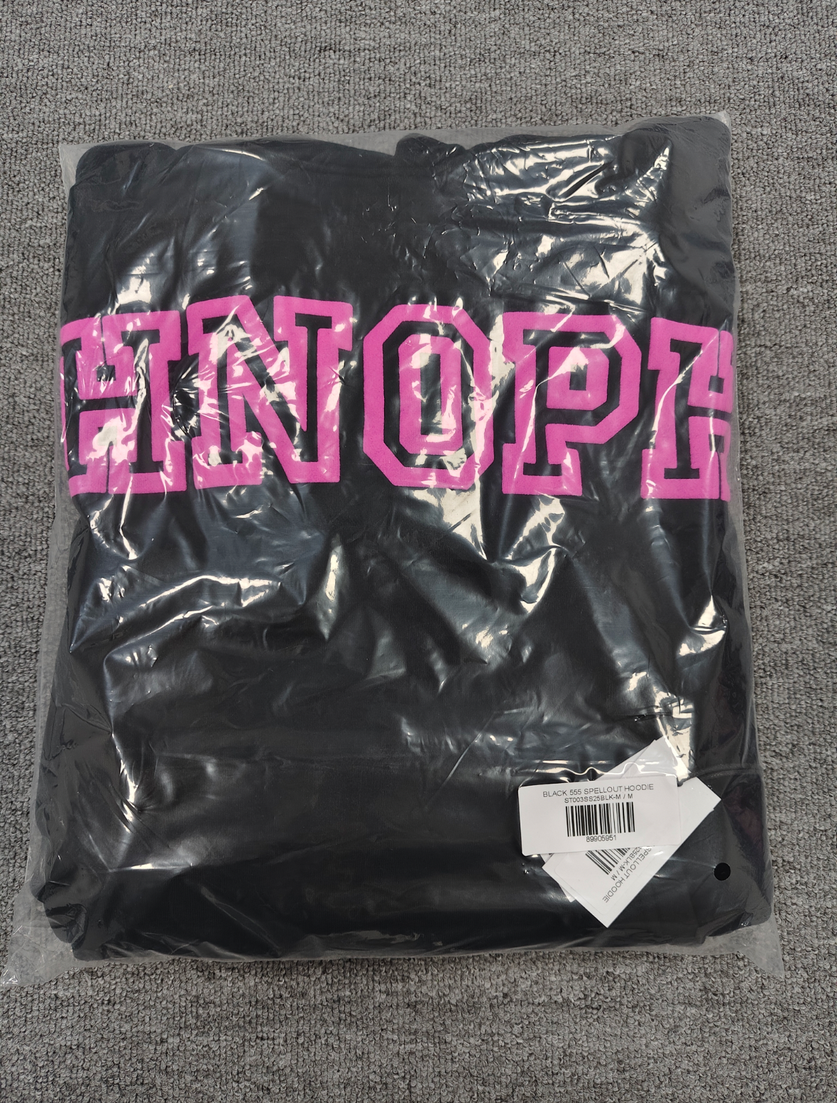 a black Sp5der Arachnophobia hoodie with vibrant pink lettering