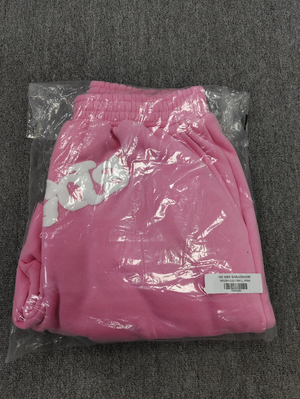 pink Sp5der jogger shorts feature a prominent white "sp5der" bubble letter graphic across the front