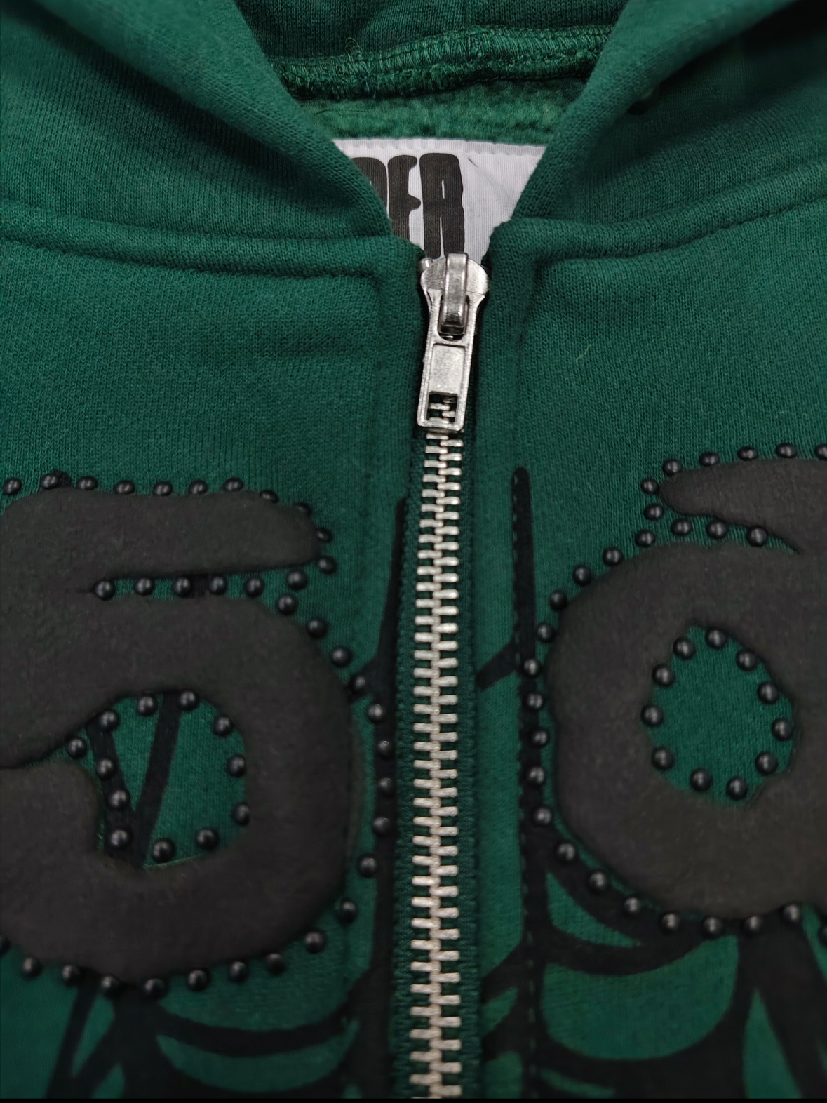 Sp5der OG Web Studded Zip Hoodie in green featuring black graphic detailing