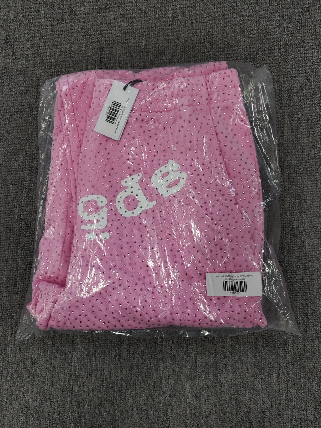 pink Sp5der sweatpants feature an all-over tonal rhinestone application and a SP5DER logo printed across the crotch