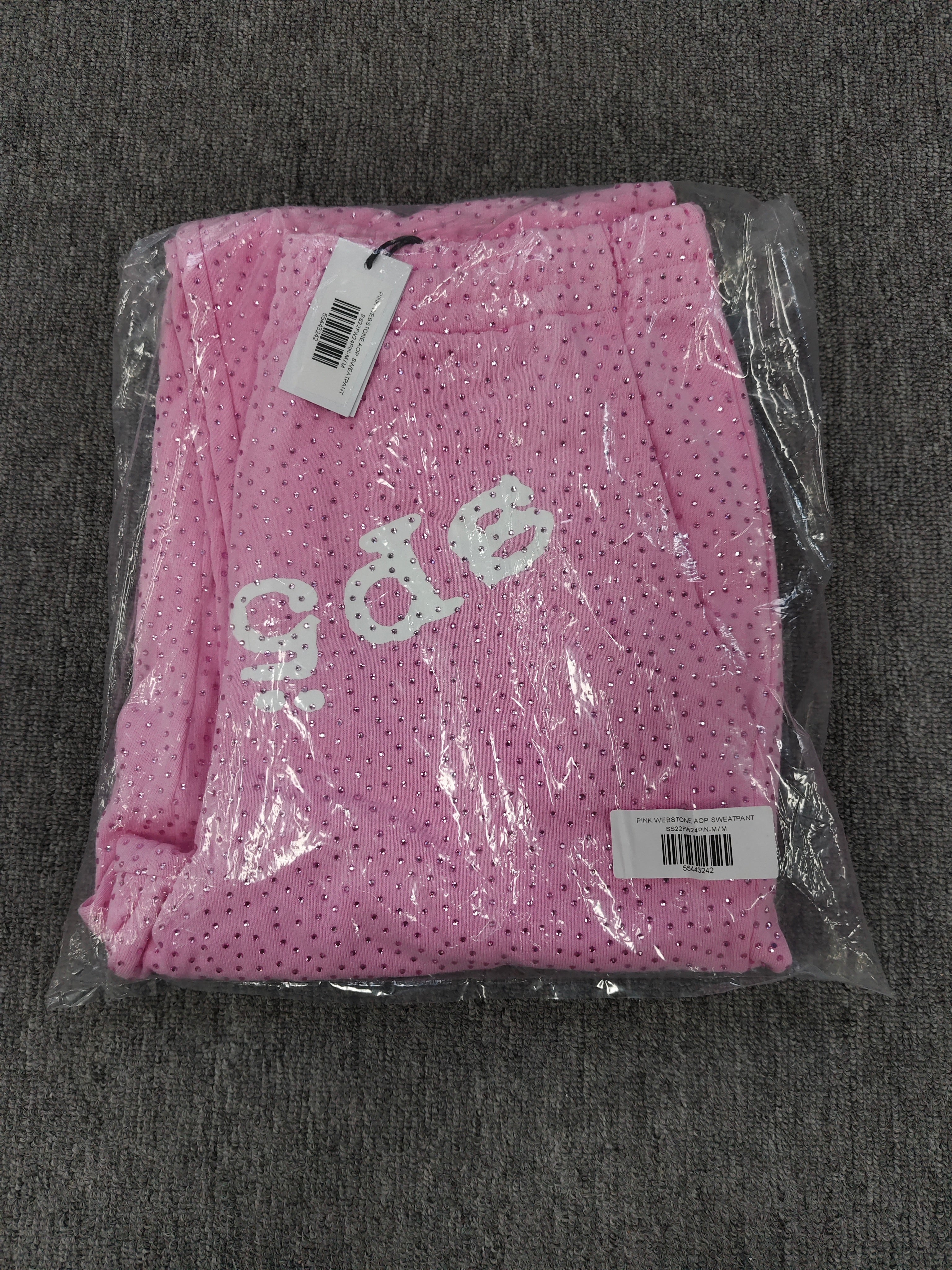 pink Sp5der sweatpants feature an all-over tonal rhinestone application and a SP5DER logo printed across the crotch