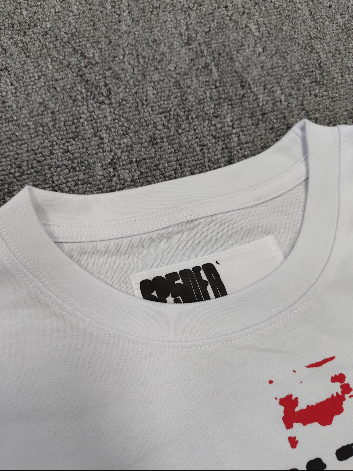 Sp5der Spinner T-Shirt in white, featuring a distinctive red web graphic and black lettering