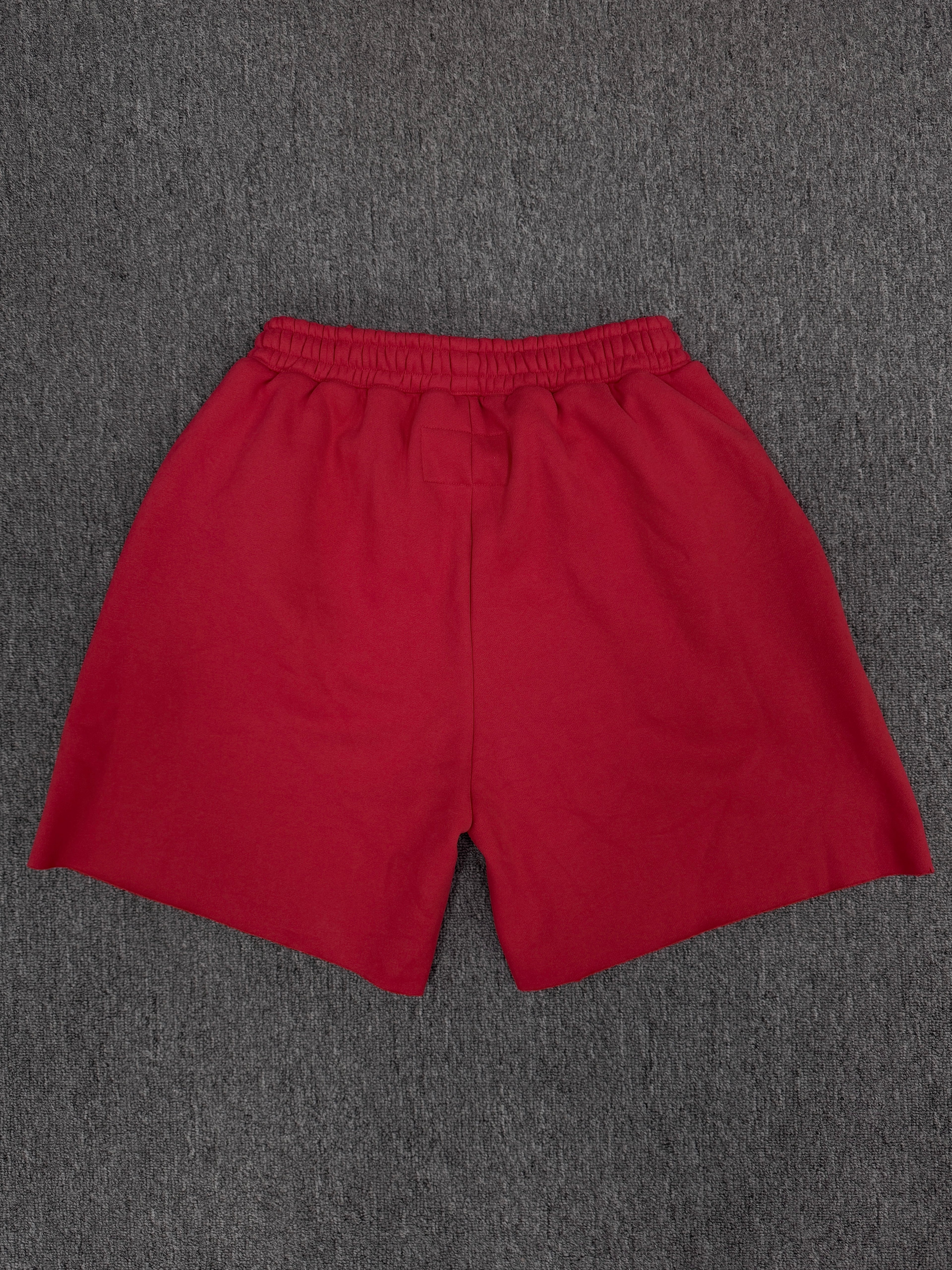 red Sp5der Angel Number Shorts featuring pink "555" graphics and star-shaped paint splatters