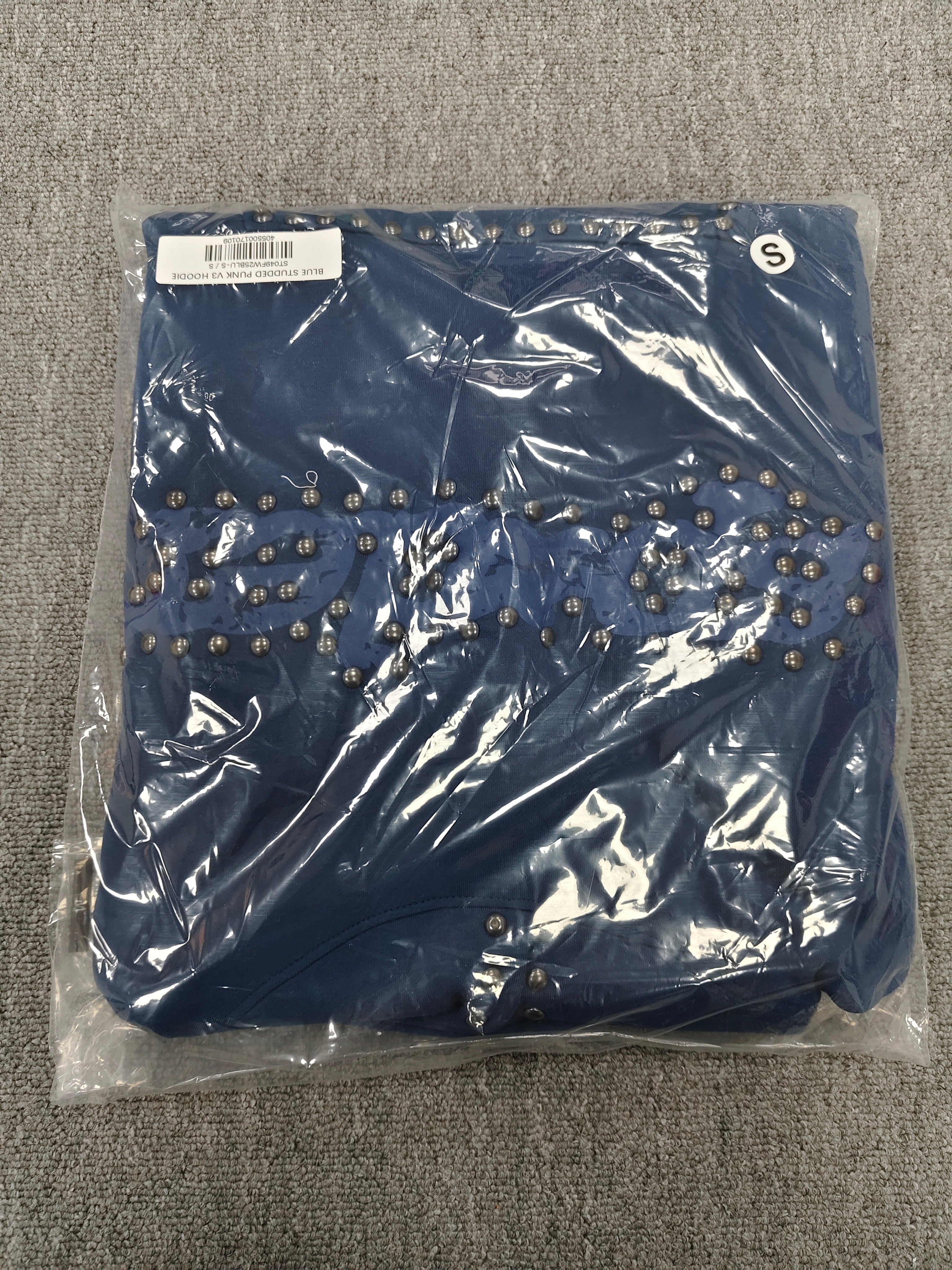 a blue Sp5der Punk V3 Studded Hoodie, featuring rhinestone-accented branding and silver stud details along the hood, logo, and pocket