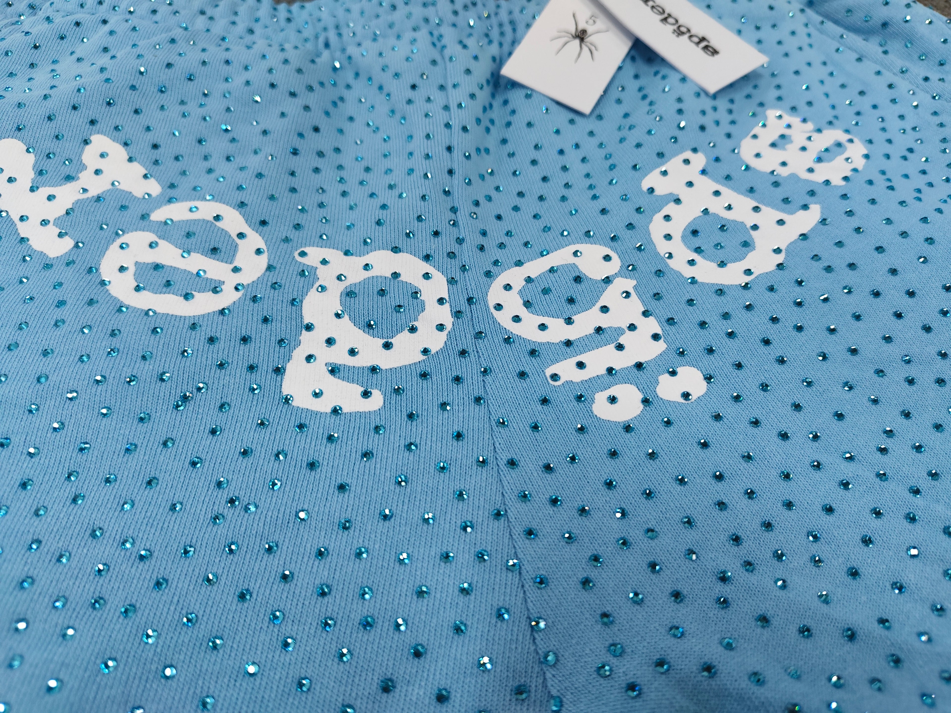 sky blue Sp5der Classic Sweatpants feature an all-over rhinestone design and the brand's logo in a sparkling applique