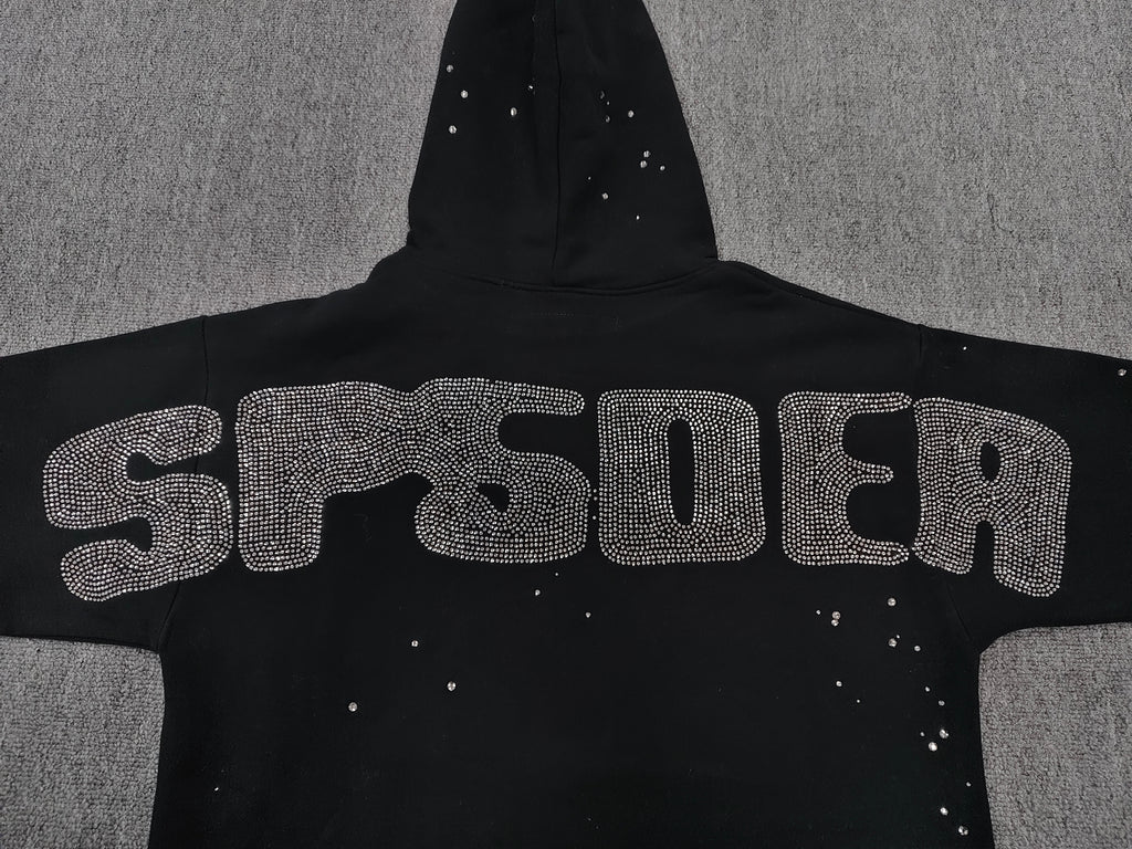 a Sp5der Rhinestone Silk Hoodie in black, featuring a prominent rhinestone web graphic on the front