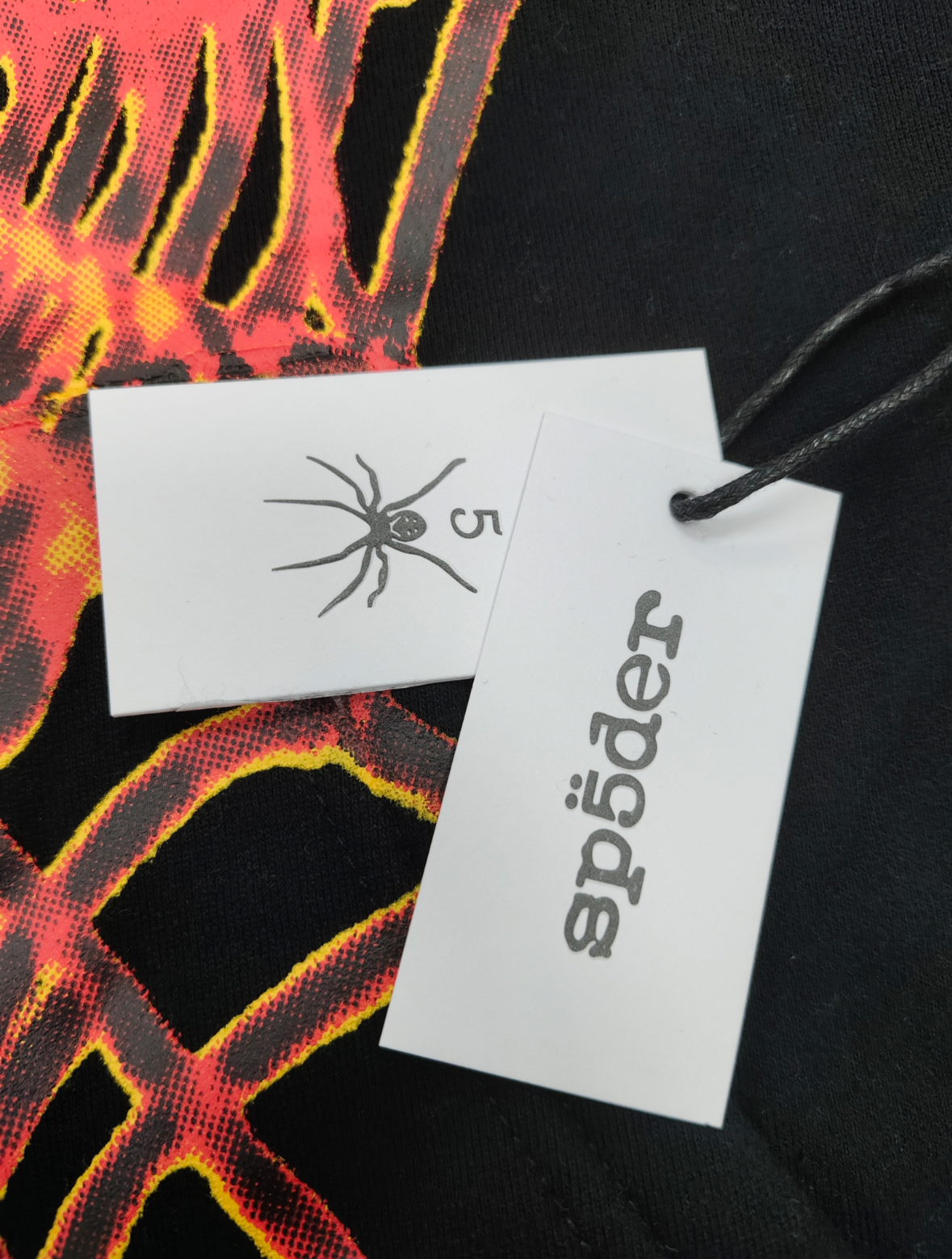 a Sp5der OG Web V2 Hoodie in a fire-like orange contrast on a black base.