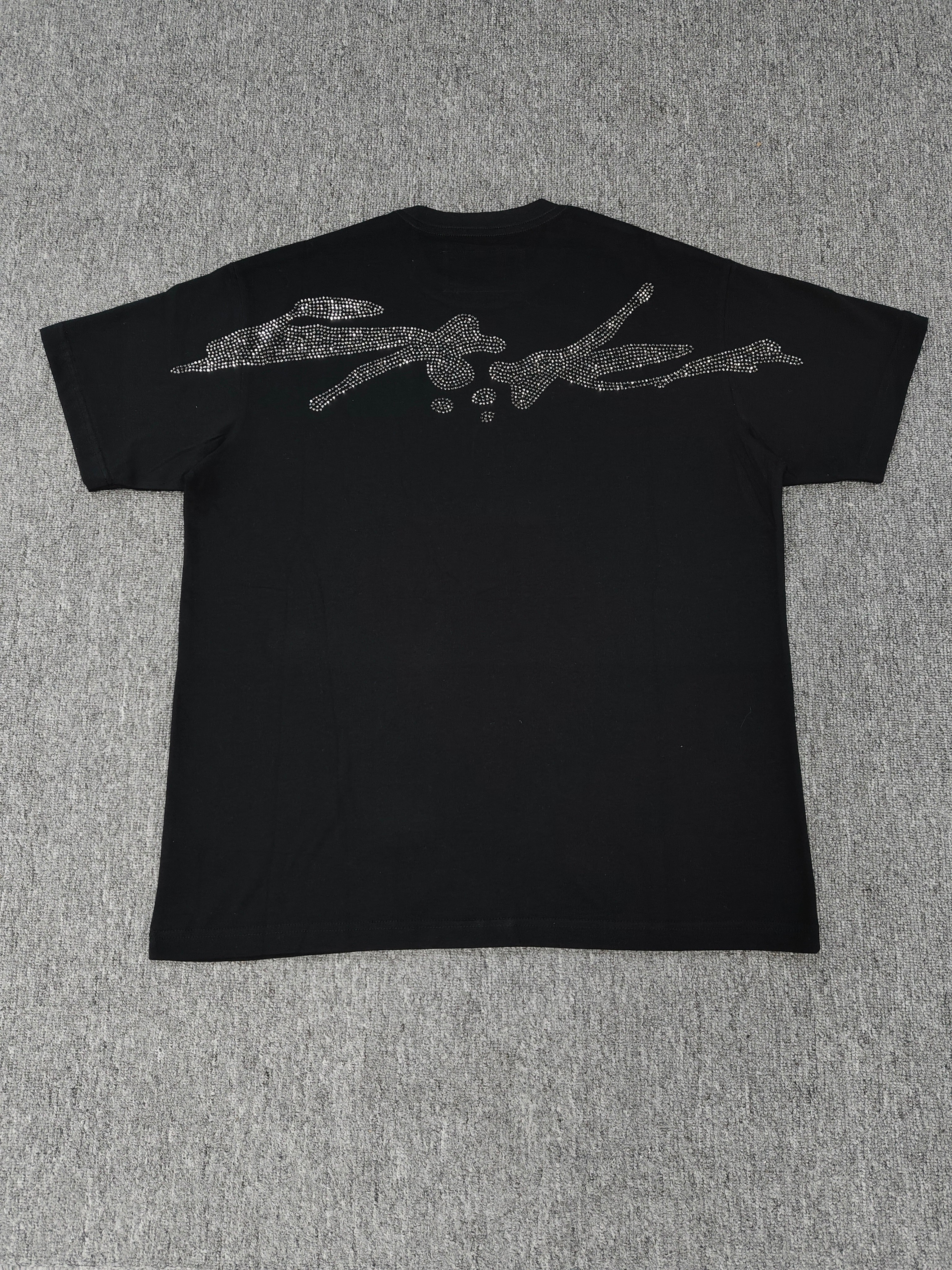 black Sp5der TM rhinestone tee features a central spider motif constructed from sparkling rhinestones