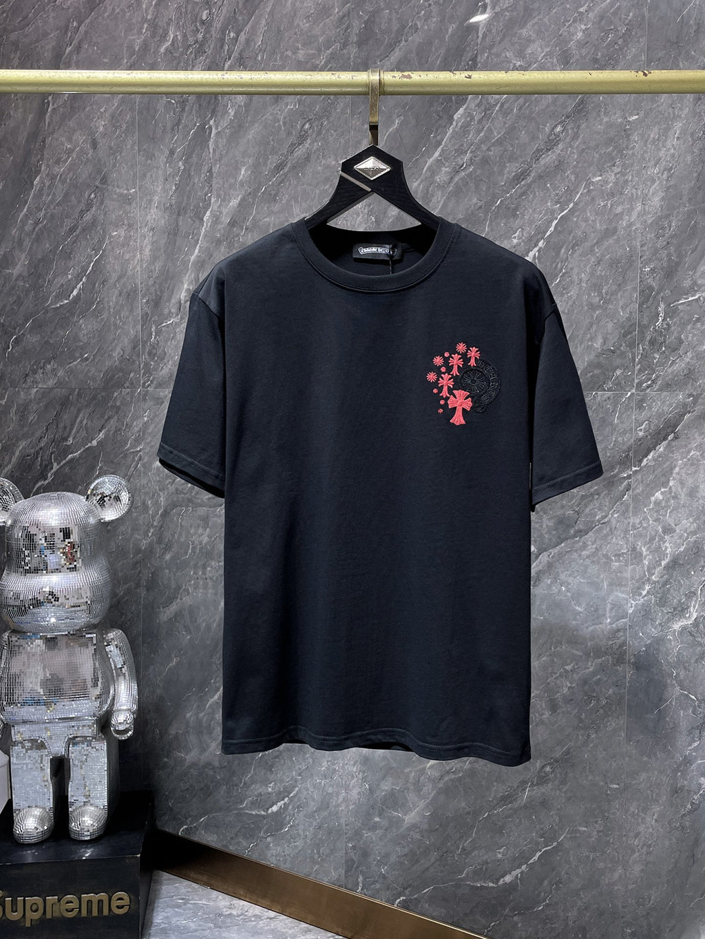 a Chrome Hearts branded short-sleeve t-shirt featuring distinctive embroidered gothic cross and horseshoe graphic details on the back