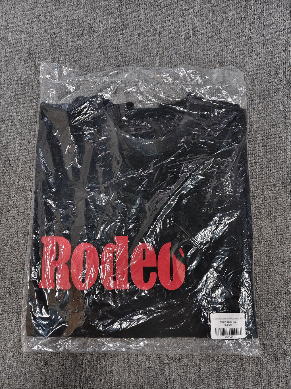 a black Travis Scott x Sp5der "Days Before Rodeo" collaboration t-shirt featuring a distinctive red "Rodeo" graphic and faded branding
