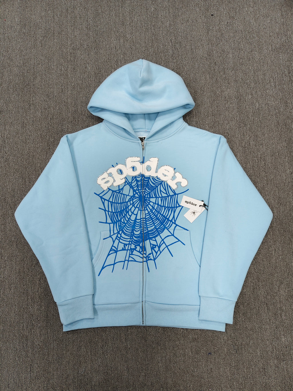 Sp5der OG Web Zip Up hoodie in Sky Blue features a prominent 3D puff-printed spider web graphic and rhinestone embellishments