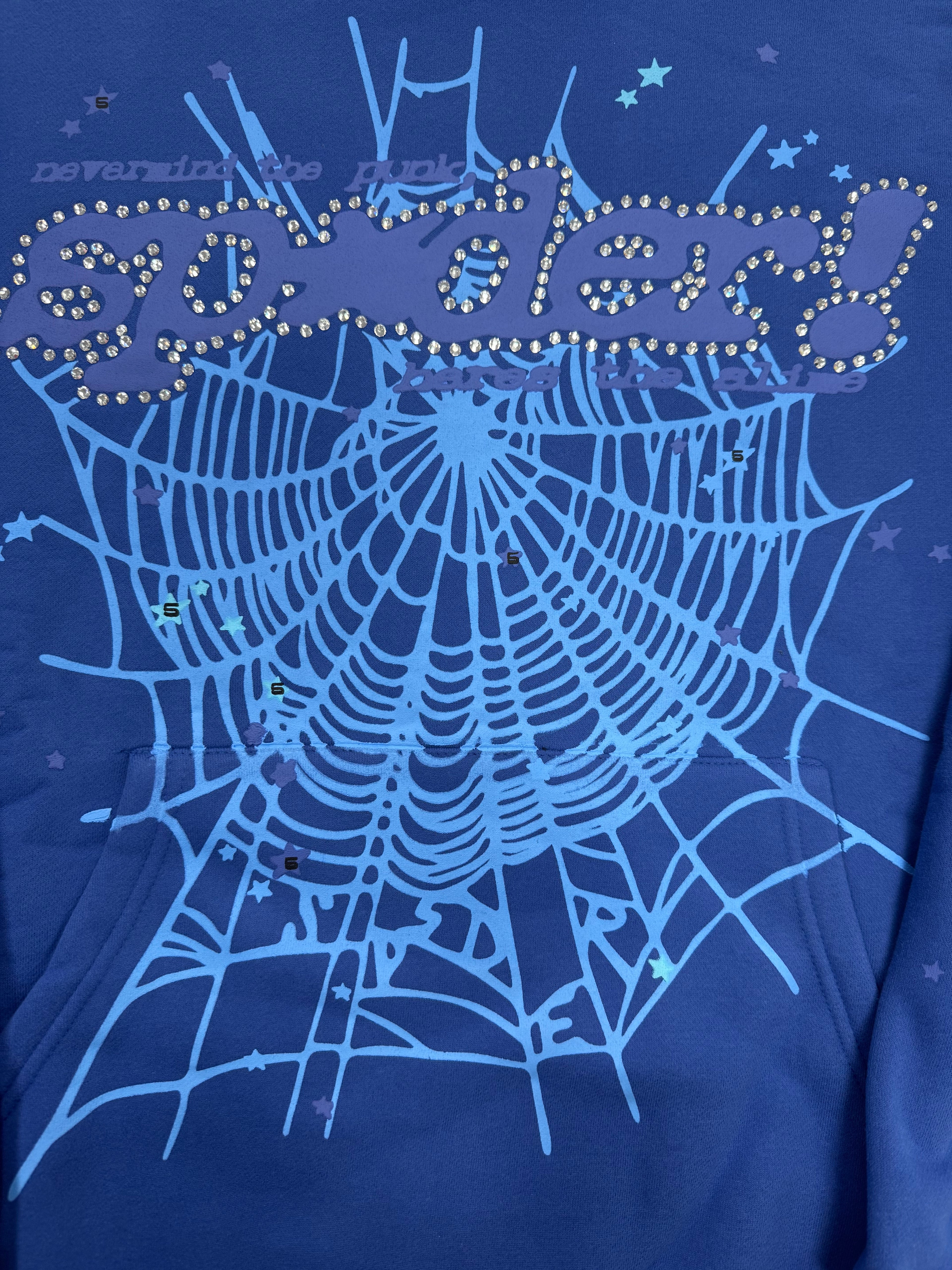 blue hoodie is a SP5DER Punk V2 model featuring a prominent spider-web graphic with rhinestone embellishments