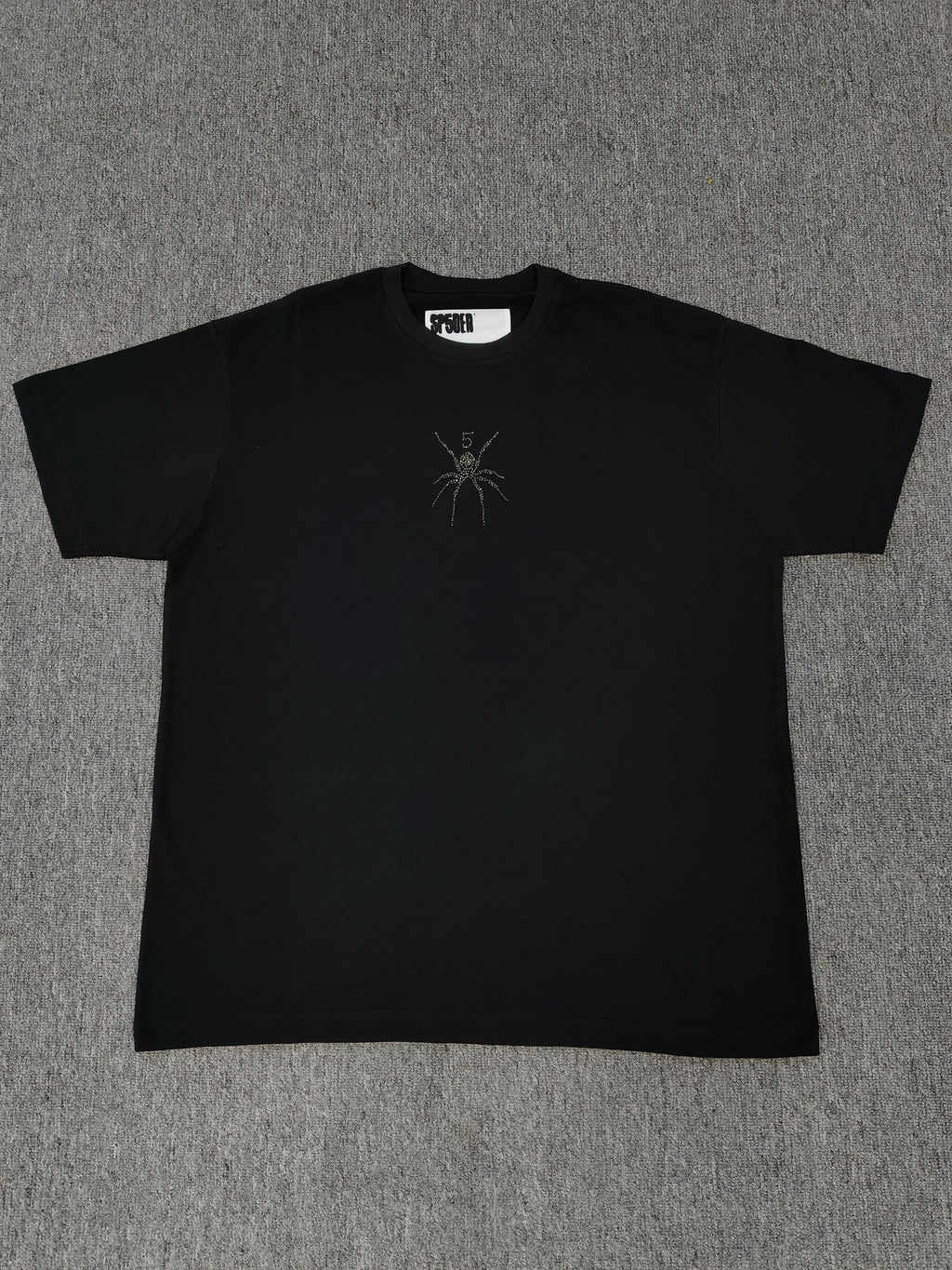 black Sp5der TM rhinestone tee features a central spider motif constructed from sparkling rhinestones