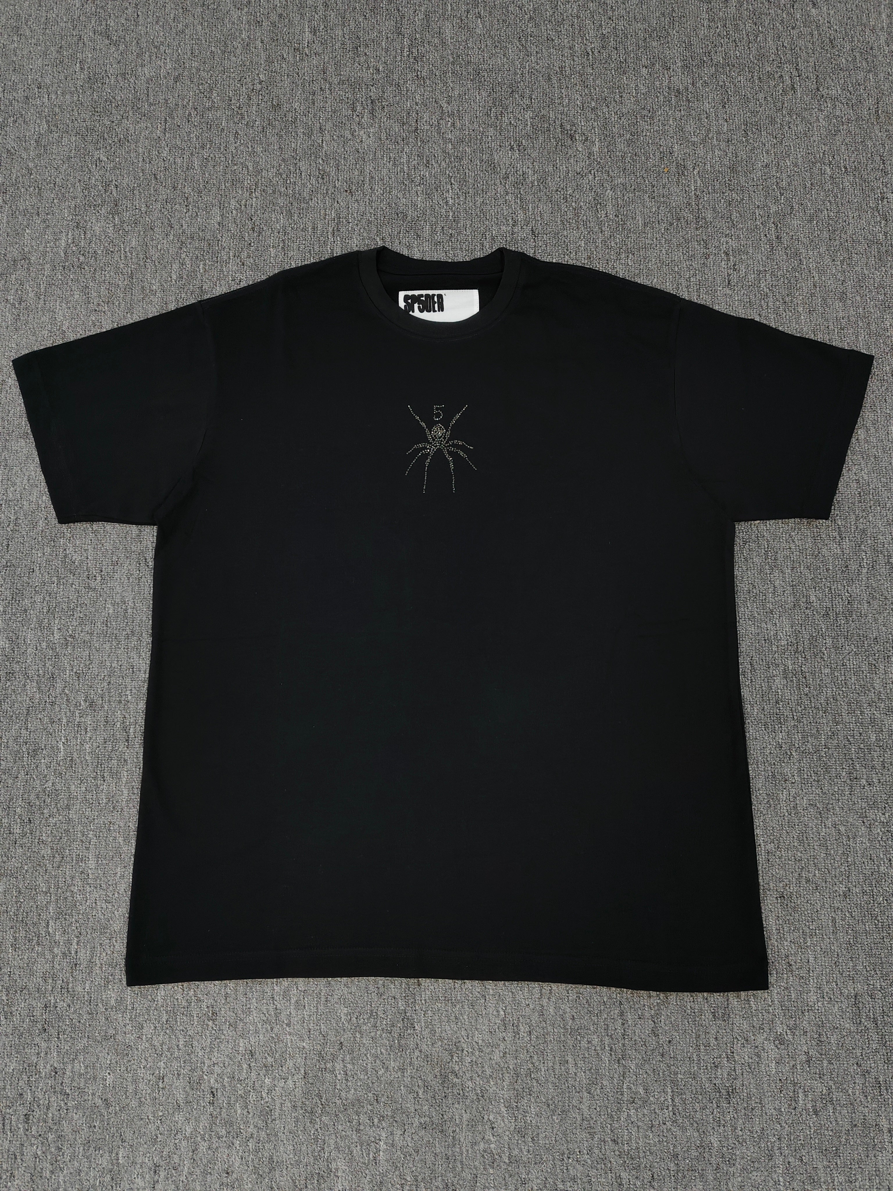 black Sp5der TM rhinestone tee features a central spider motif constructed from sparkling rhinestones