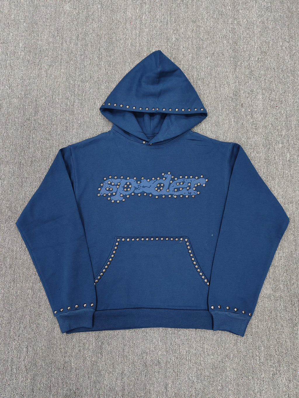a blue Sp5der Punk V3 Studded Hoodie, featuring rhinestone-accented branding and silver stud details along the hood, logo, and pocket