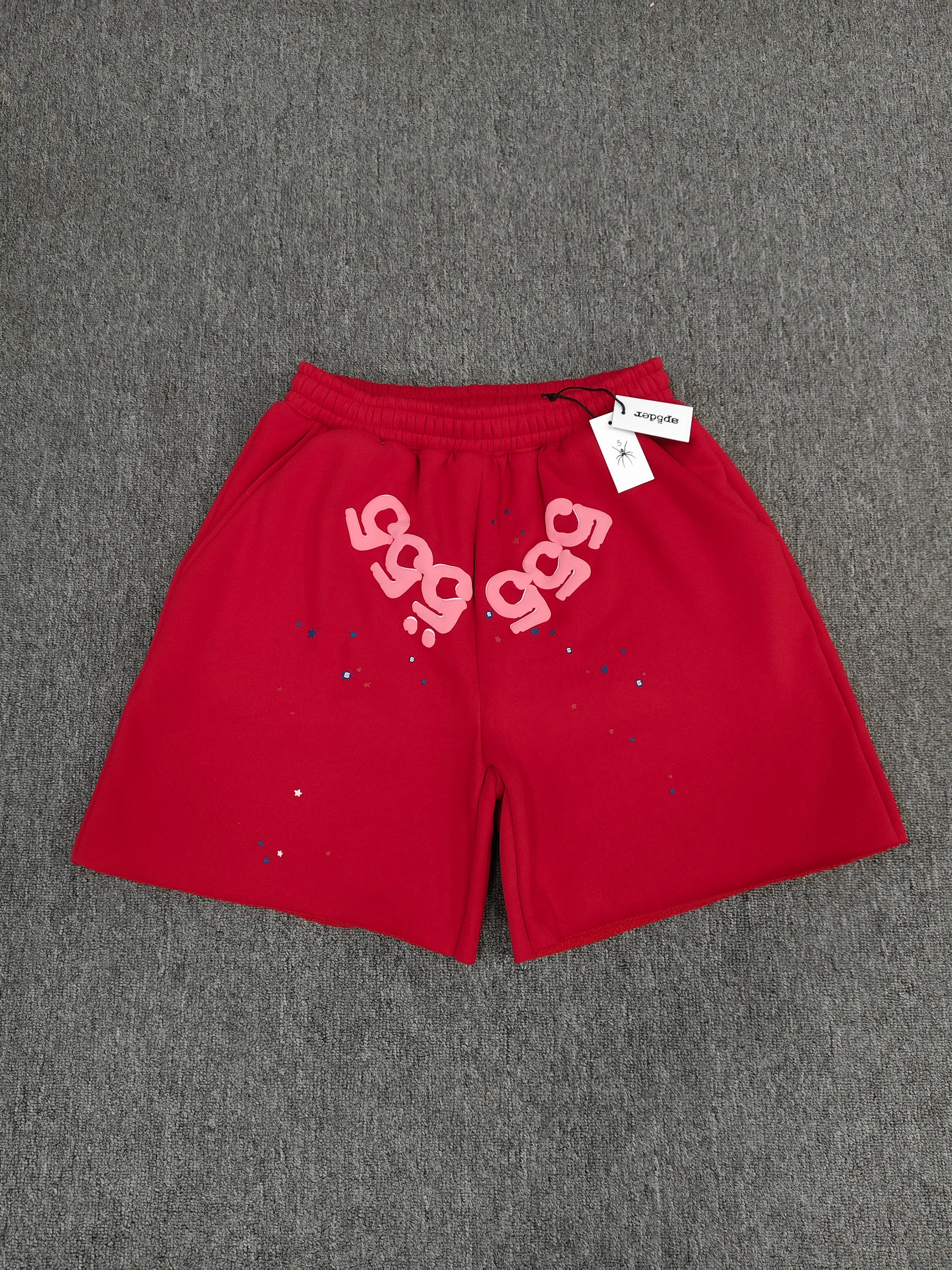 red Sp5der Angel Number Shorts featuring pink "555" graphics and star-shaped paint splatters