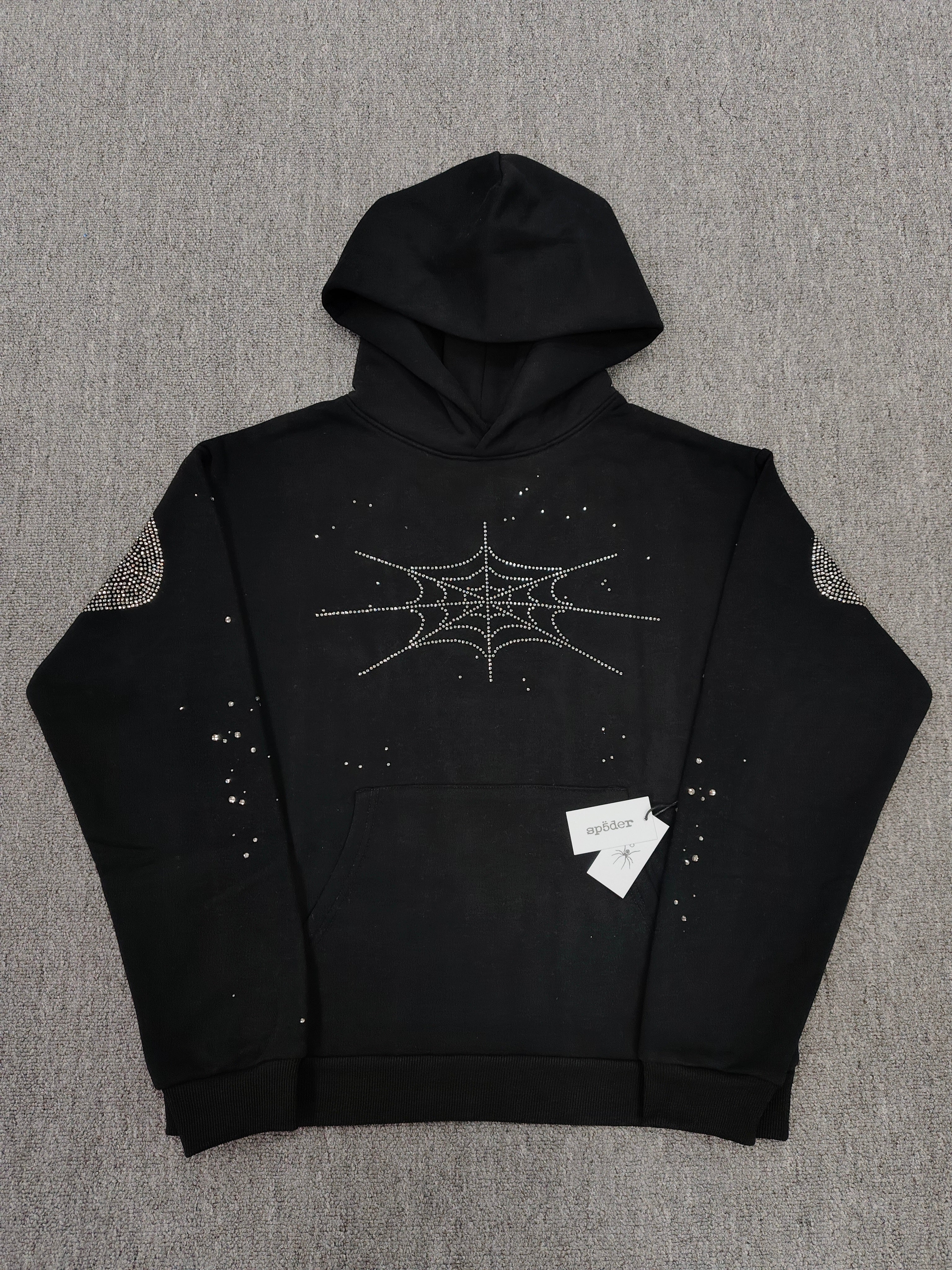 a Sp5der Rhinestone Silk Hoodie in black, featuring a prominent rhinestone web graphic on the front