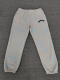 Sp5der AOP Web Heather Grey Sweatpants featuring a distinctive all-over blue spiderweb print and a contrasting black logo on the thigh.