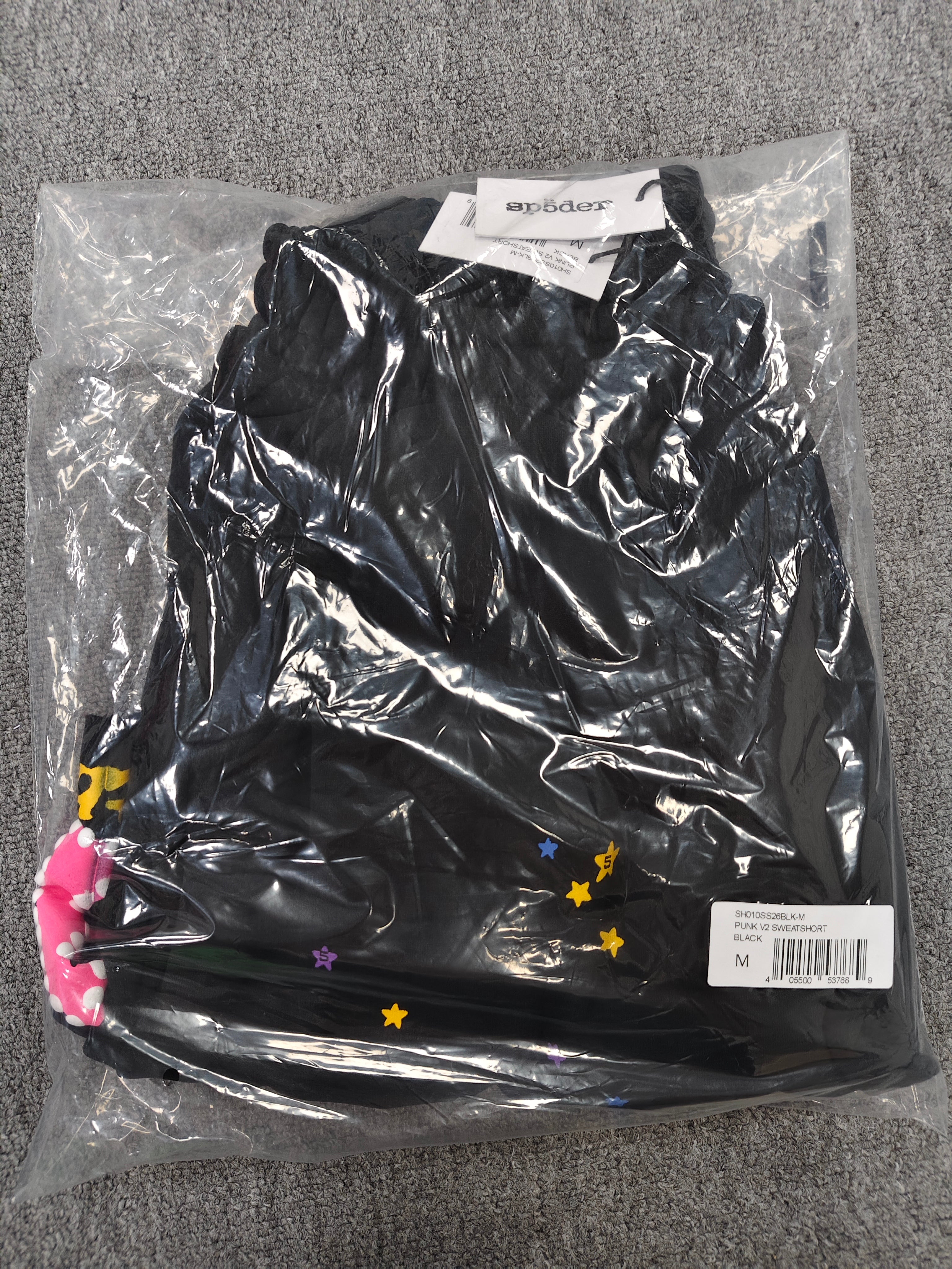 Sp5der Punk V2 shorts in black, featuring a vibrant pink logo and scattered colorful stars