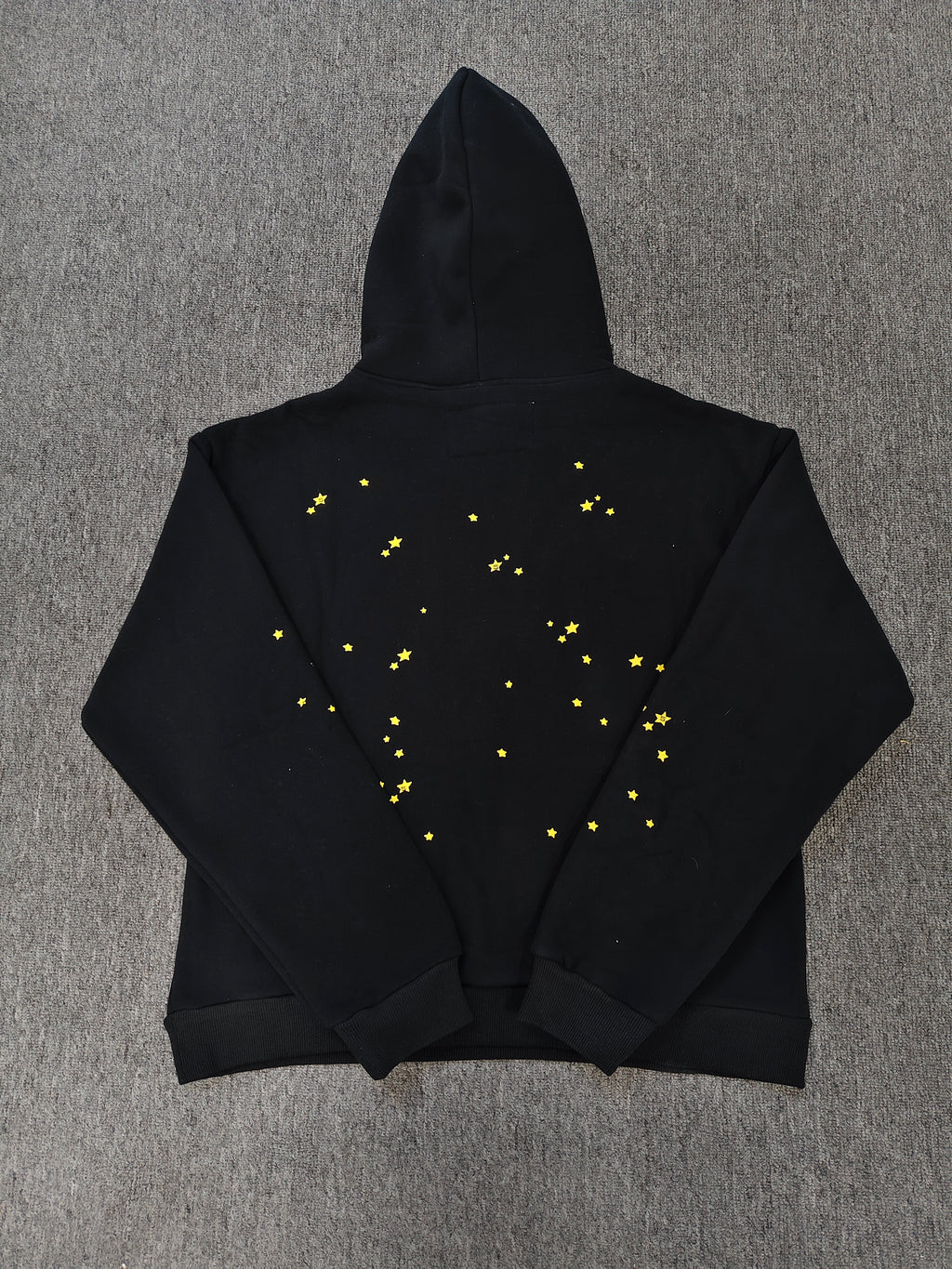 black SP5DER Atlanta hoodie features yellow lettering, red stars, and a spiderweb graphic