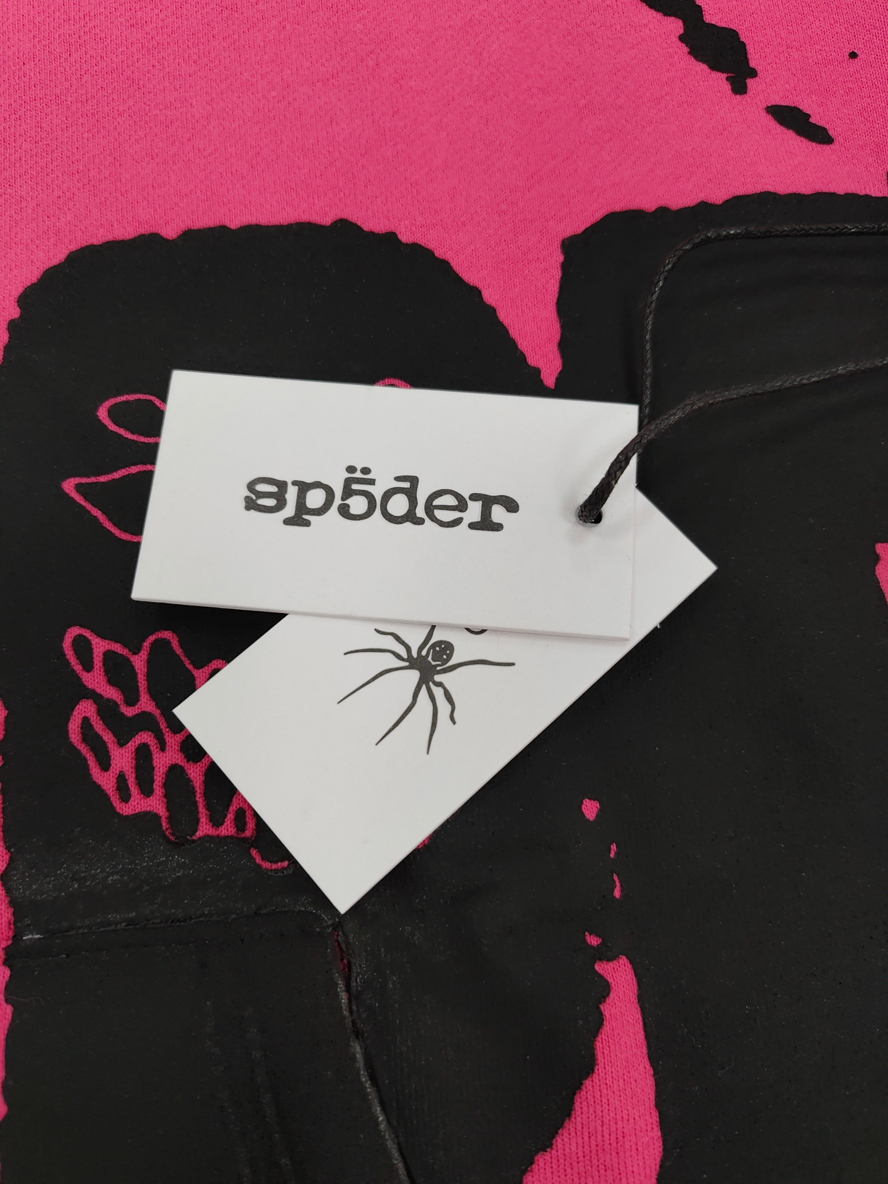 hot pink Sp5der hoodie featuring large, bold black screen-printed graphics on the front and arms.