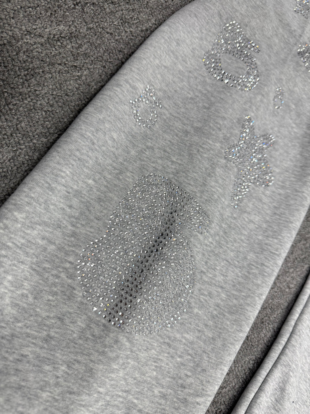 light grey sp5der joggers feature a unique rhinestone across the front hip area