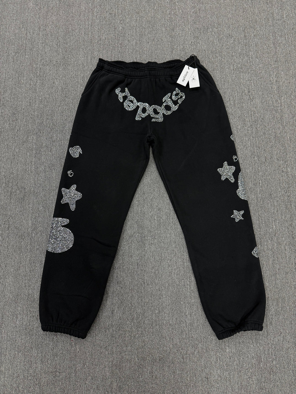 Sp5der OG Web Sweatpants in black, featuring distinctive rhinestone logo and star graphics