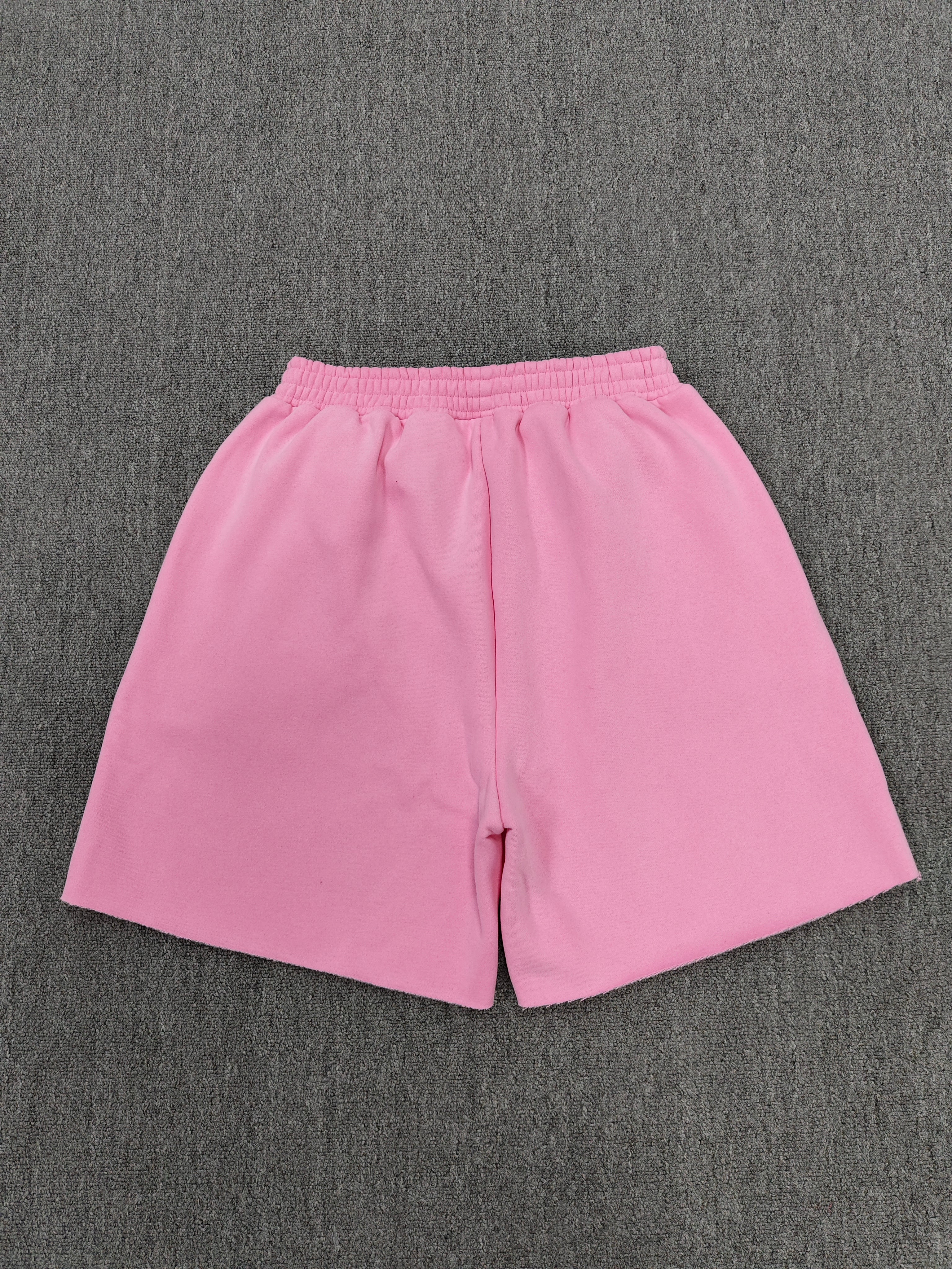 pink Sp5der jogger shorts feature a prominent white "sp5der" bubble letter graphic across the front