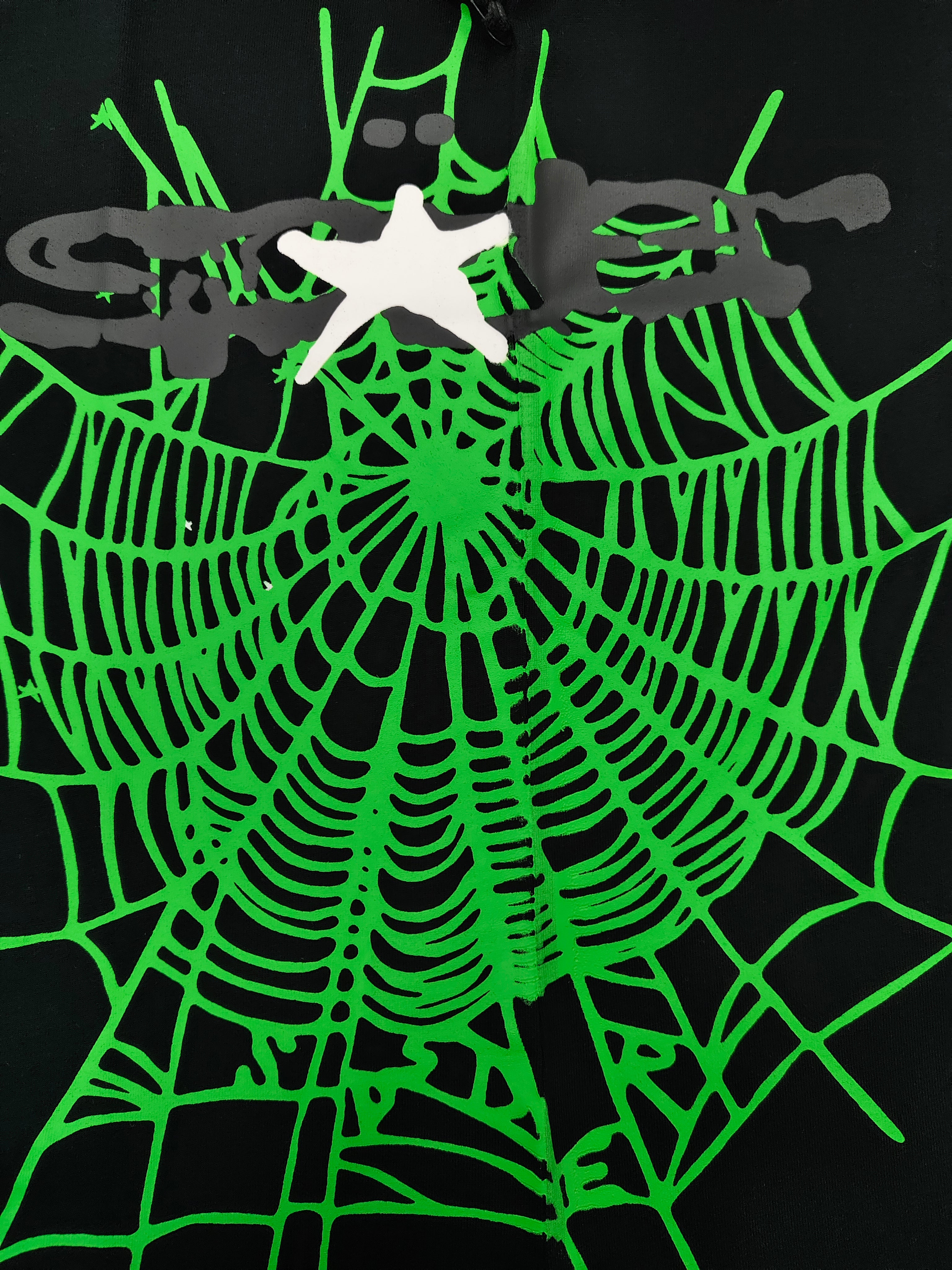 a Sp5der Heavy Web T-shirt in black featuring a prominent neon green web graphic and scattered star print