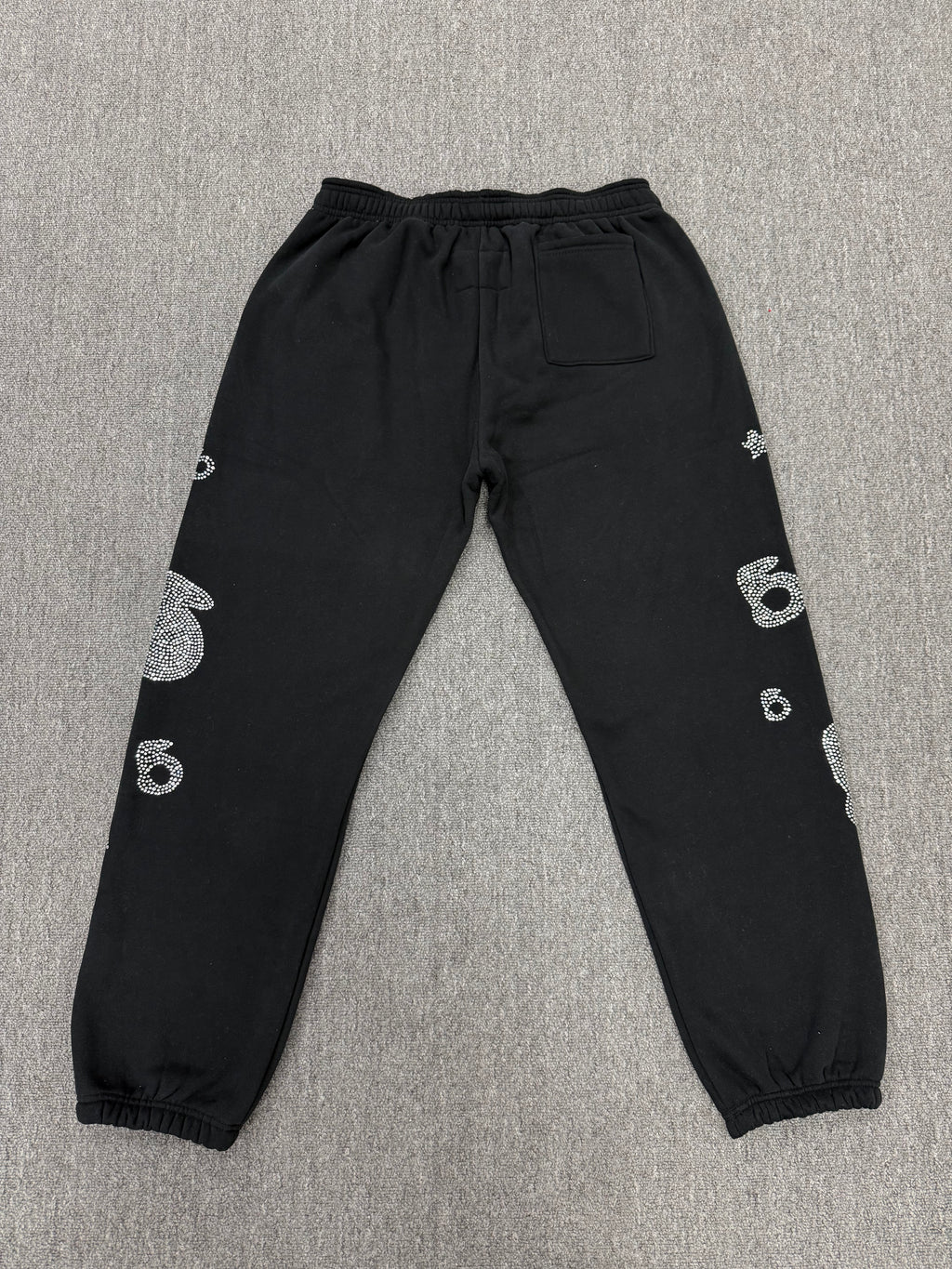 Sp5der OG Web Sweatpants in black, featuring distinctive rhinestone logo and star graphics