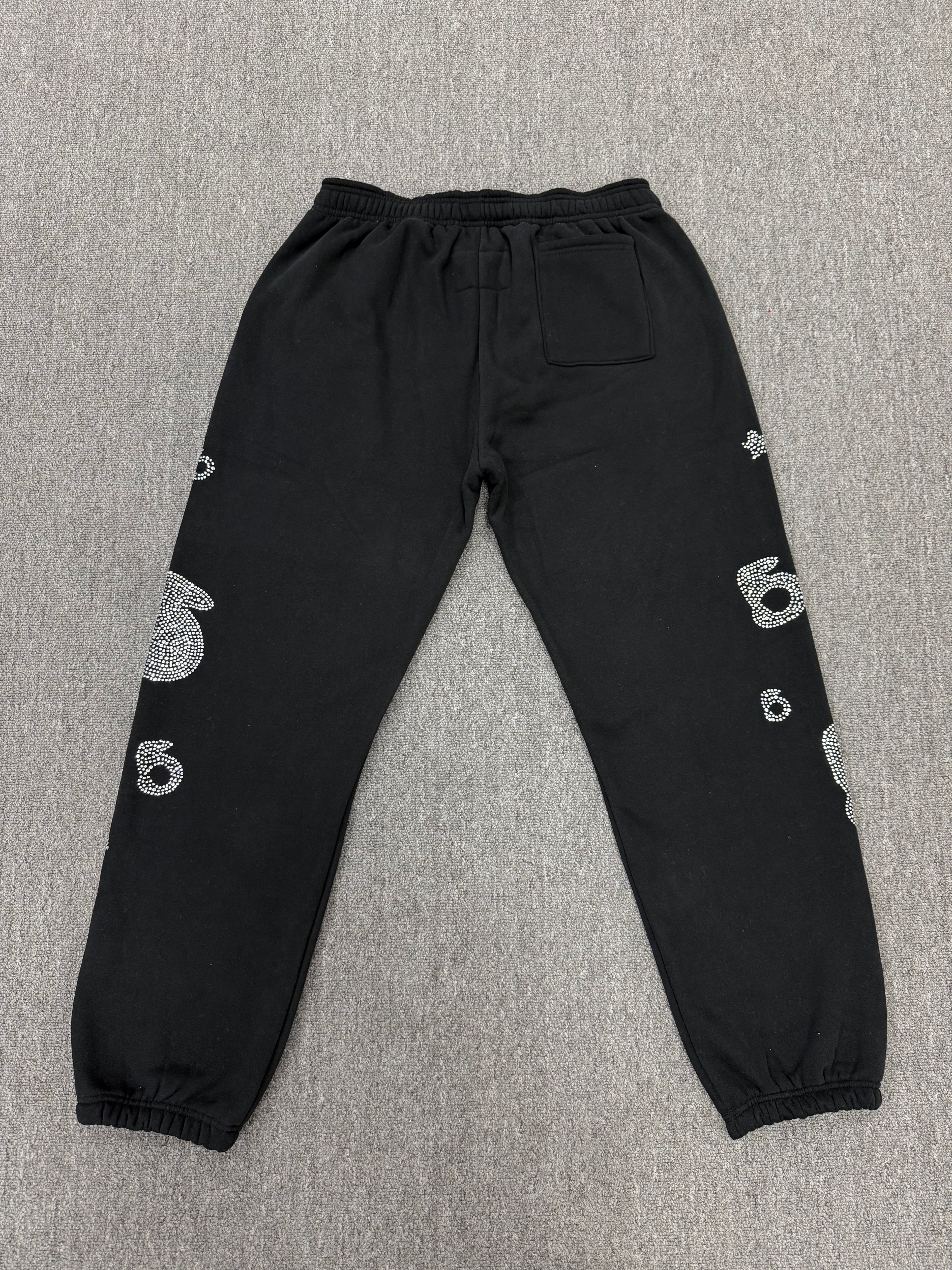 Sp5der OG Web Sweatpants in black, featuring distinctive rhinestone logo and star graphics
