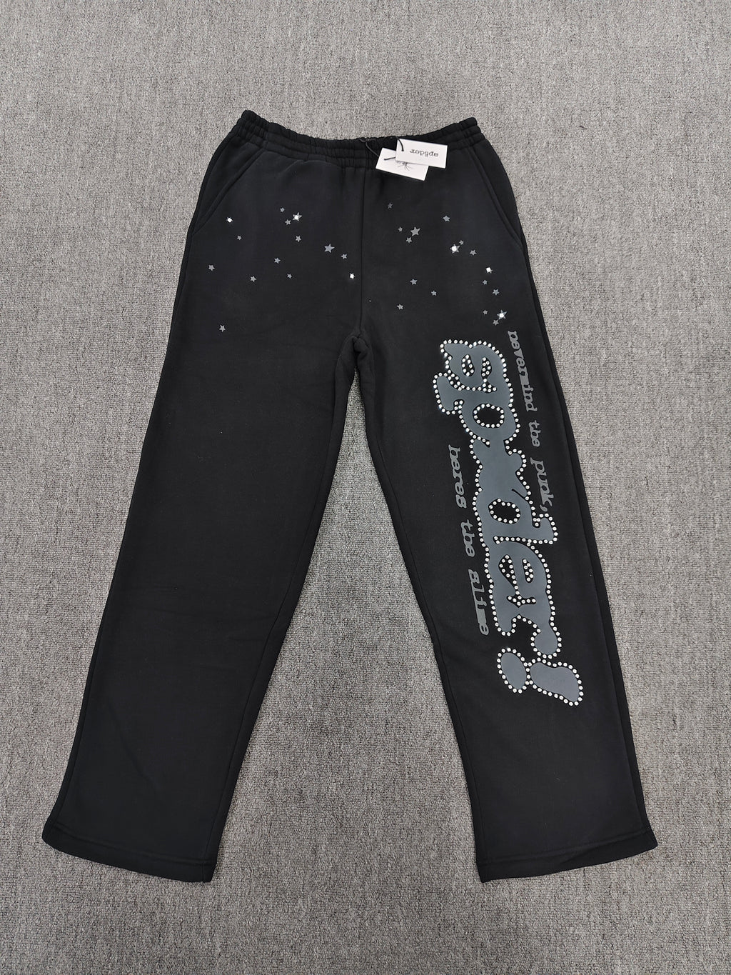 black SP5DER Rhinestone Punk V2 track pants feature rhinestone star embellishments and a rhinestone-encrusted logo