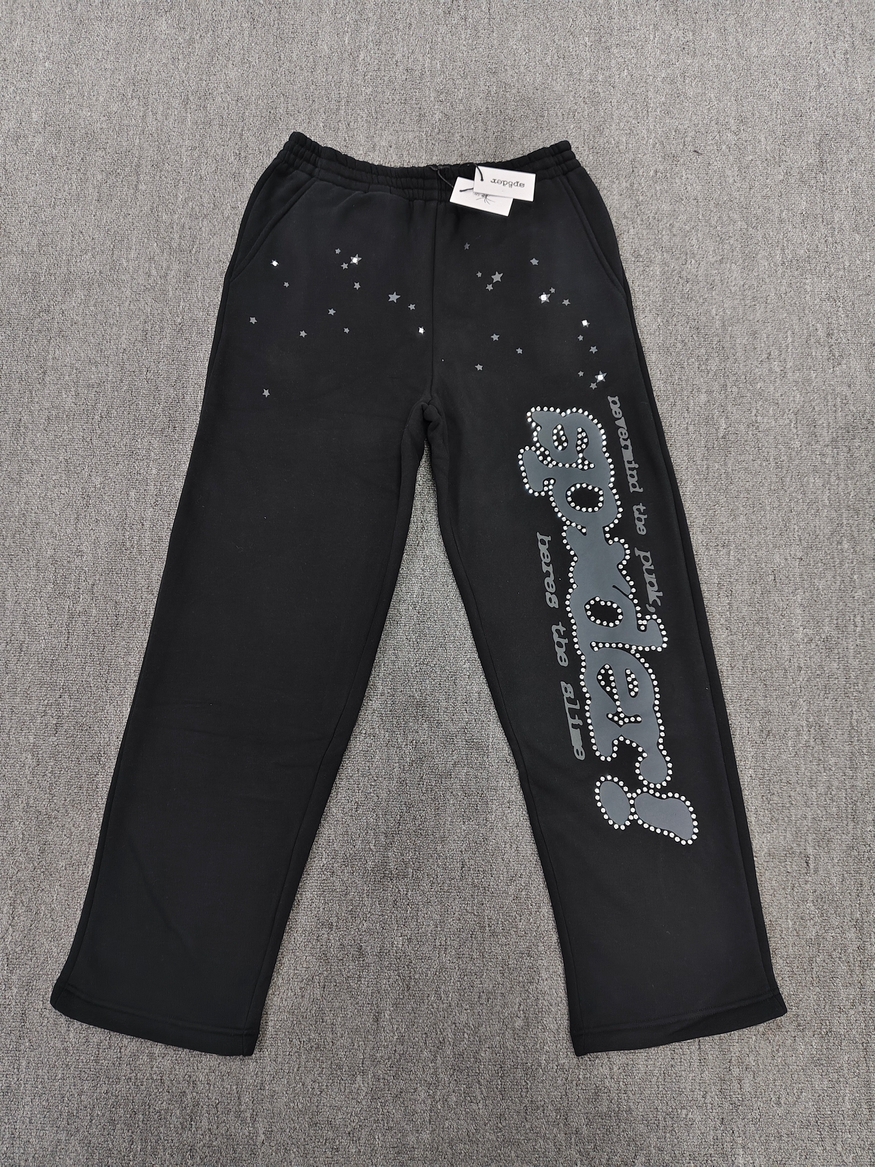 black SP5DER Rhinestone Punk V2 track pants feature rhinestone star embellishments and a rhinestone-encrusted logo