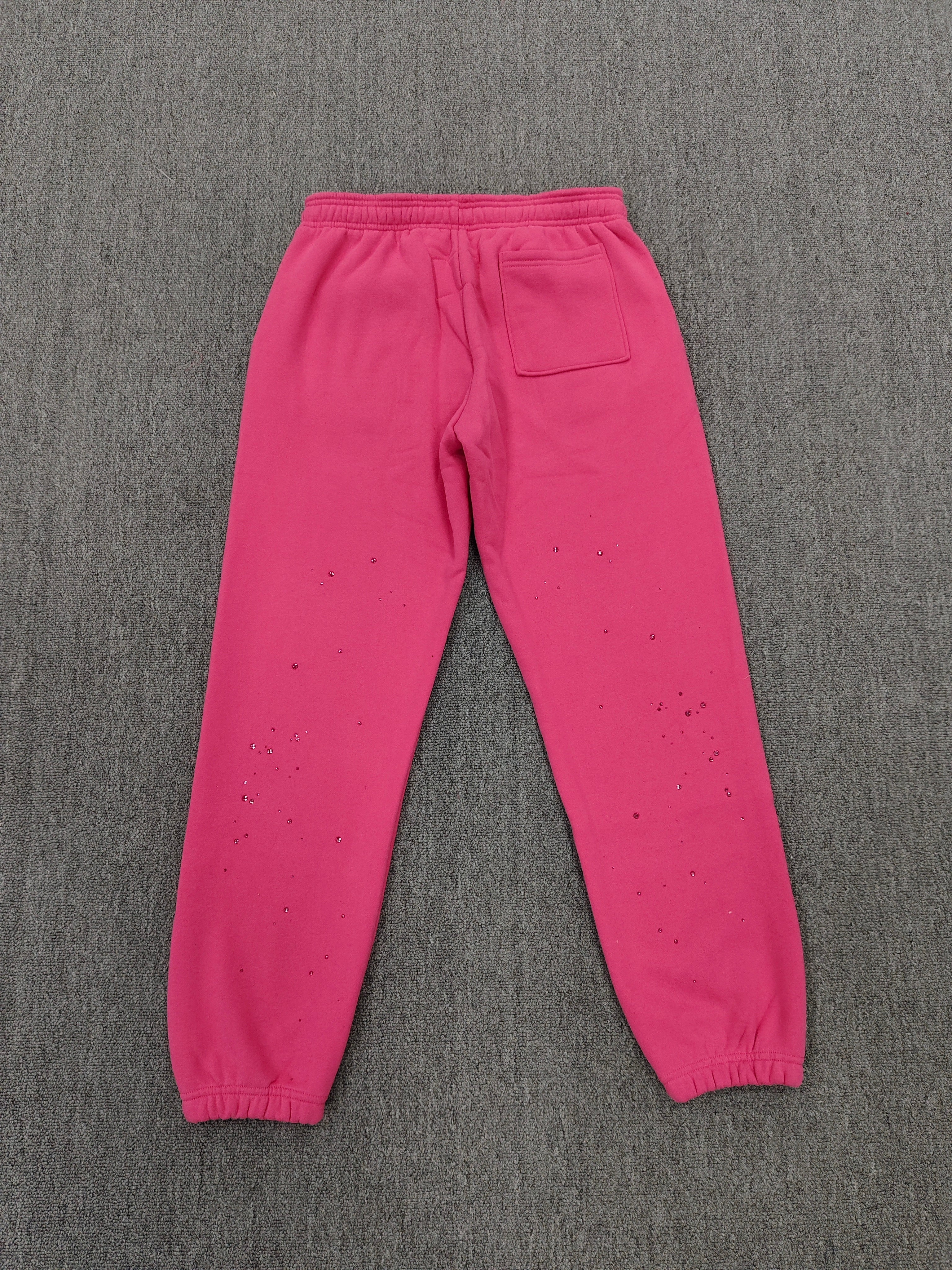 pink Sp5der sweatpants feature rhinestone branding down the leg and are identified as the Rhinestone Silk Sweatpant model
