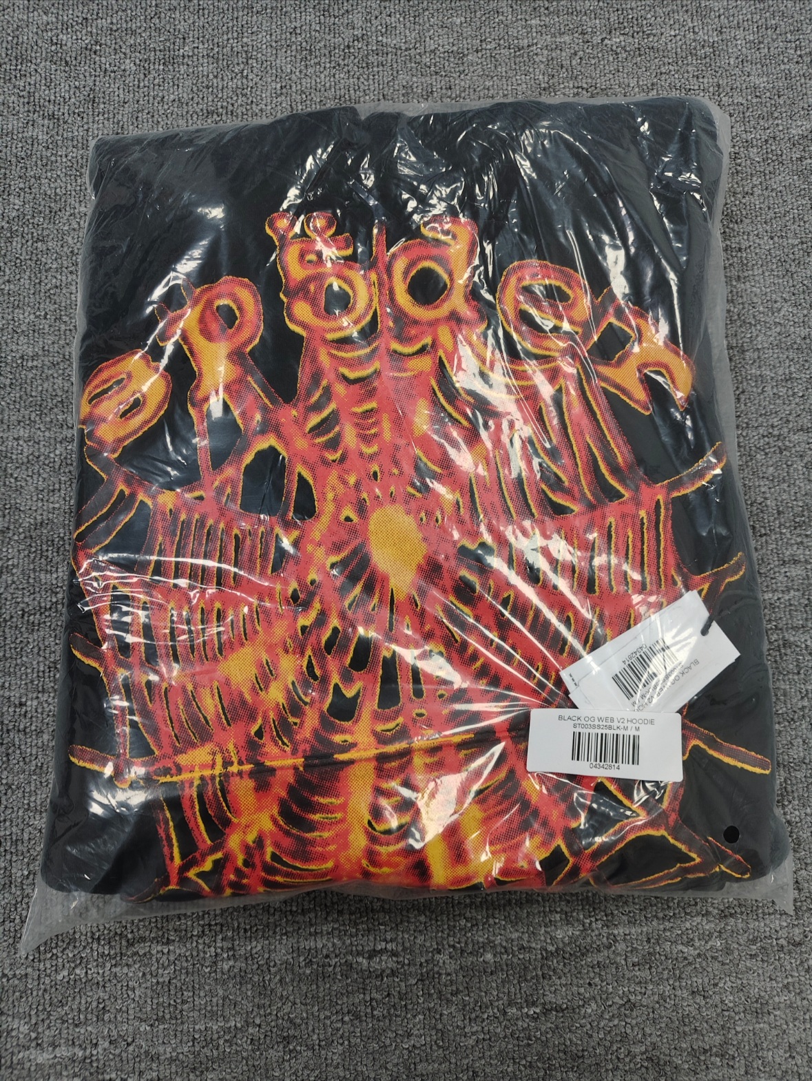 a Sp5der OG Web V2 Hoodie in a fire-like orange contrast on a black base.