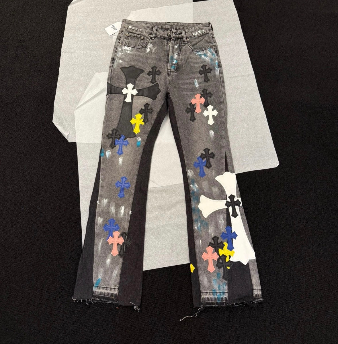 Chrome Hearts distressed jeans featuring a multicolor patchwork application of their iconic cross motif.