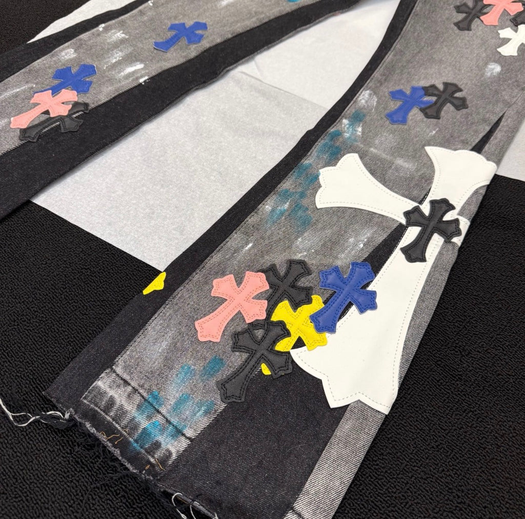 Chrome Hearts distressed jeans featuring a multicolor patchwork application of their iconic cross motif.
