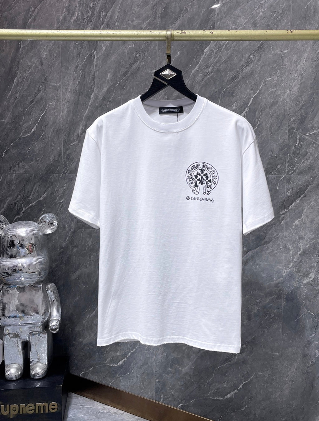 These are Chrome Hearts T-shirts featuring a large Triple Cross Horseshoe graphic in black or white