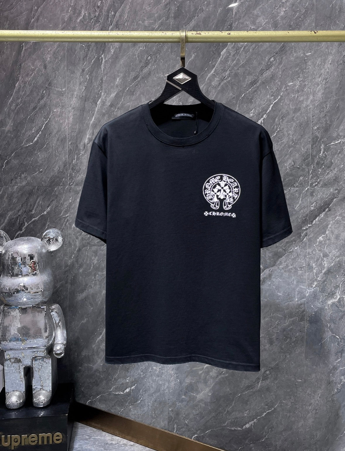 These are Chrome Hearts T-shirts featuring a large Triple Cross Horseshoe graphic in black or white