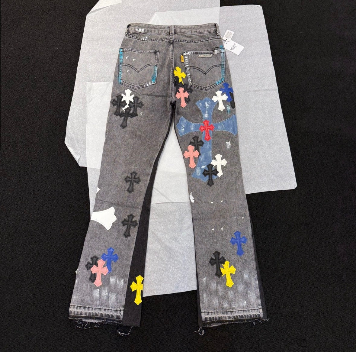 Chrome Hearts distressed jeans featuring a multicolor patchwork application of their iconic cross motif.